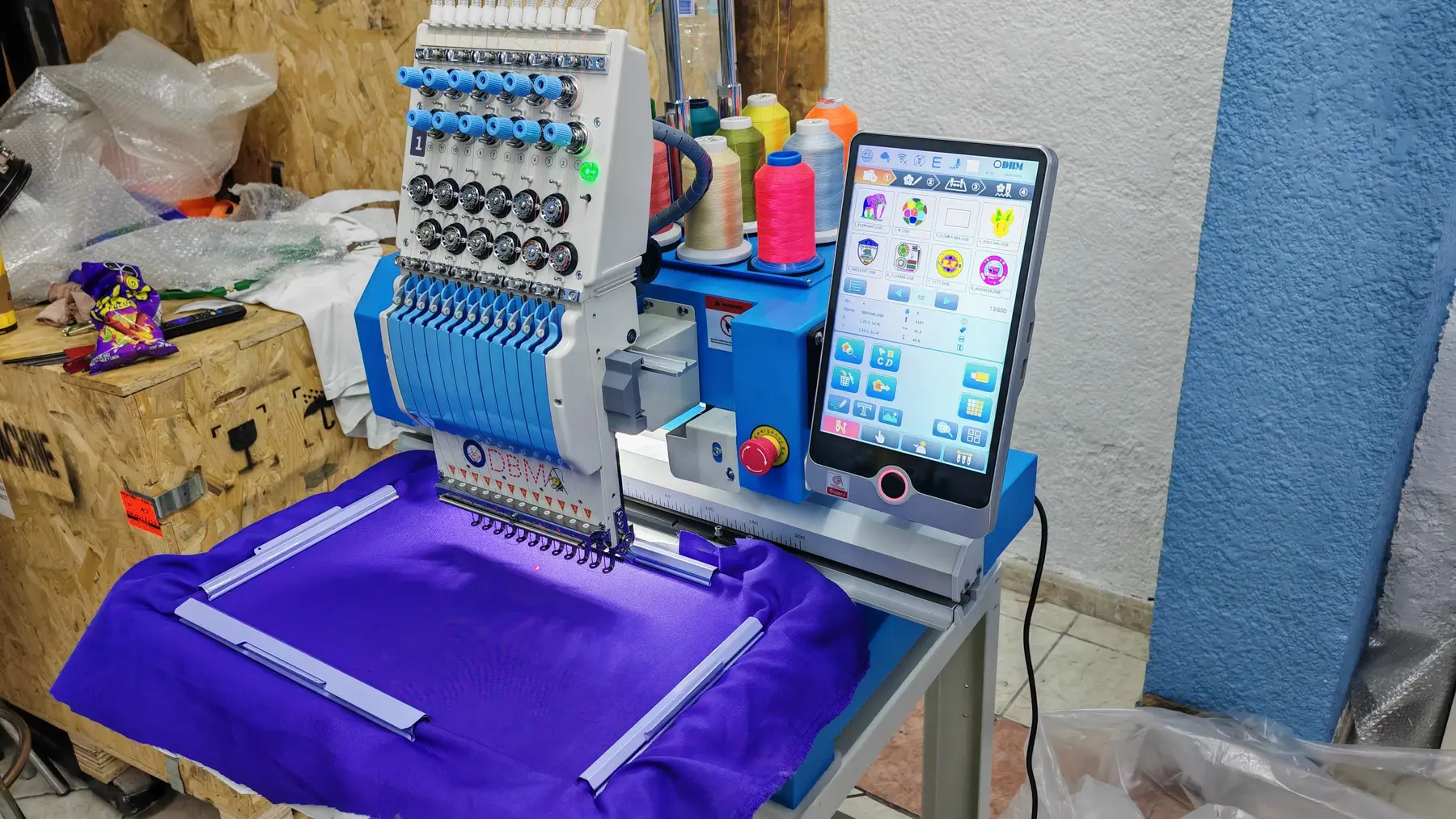 Bordadora industrial DBM trabajando sobre tela morada